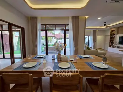 Luxurious open-plan living and dining area with elegant decor and garden view.
