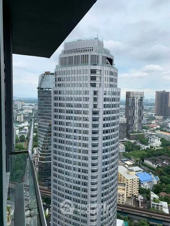 Stunning cityscape view from high-rise balcony overlooking modern skyscrapers and urban landscape.