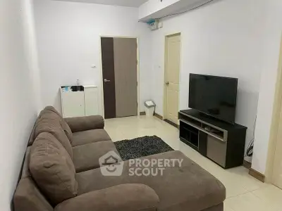 Cozy living room with plush sofa and modern TV setup, perfect for relaxation.