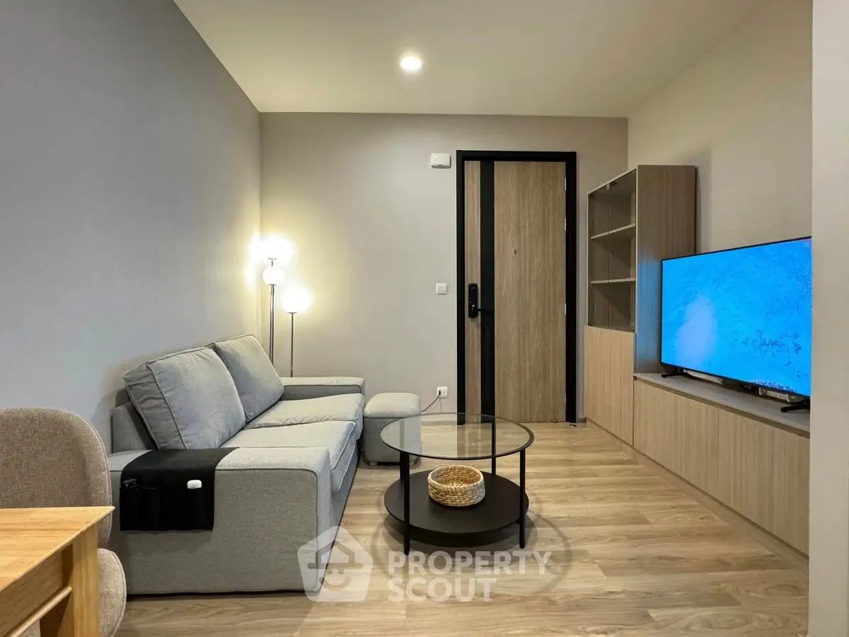 Modern living room with sleek furniture and stylish decor, featuring a cozy sofa and large TV.