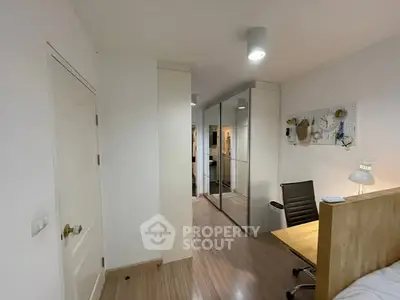 Modern study room with sleek desk and mirrored wardrobe in cozy apartment.