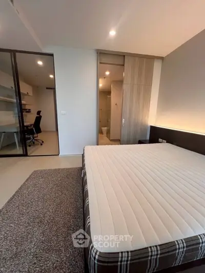 Modern bedroom with study area and ensuite bathroom in a stylish apartment