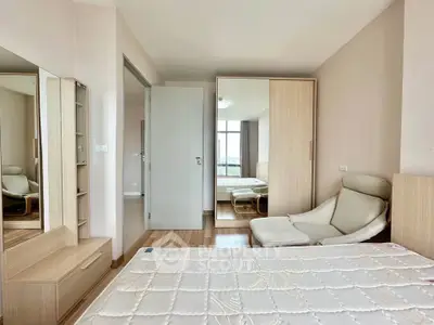 Spacious bedroom with modern furniture and large window offering natural light.