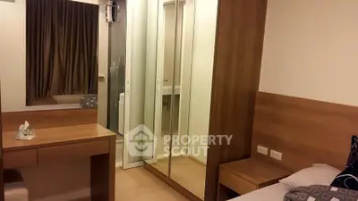 Modern bedroom with mirrored closet and wooden furniture, featuring a cozy and elegant design.