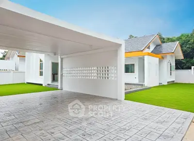 Modern single-story home with spacious driveway and lush green lawn