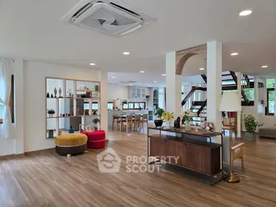 Spacious open-plan living room with modern decor and wooden flooring