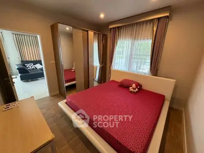 Cozy bedroom with modern decor and large window, featuring a comfortable bed and stylish curtains.