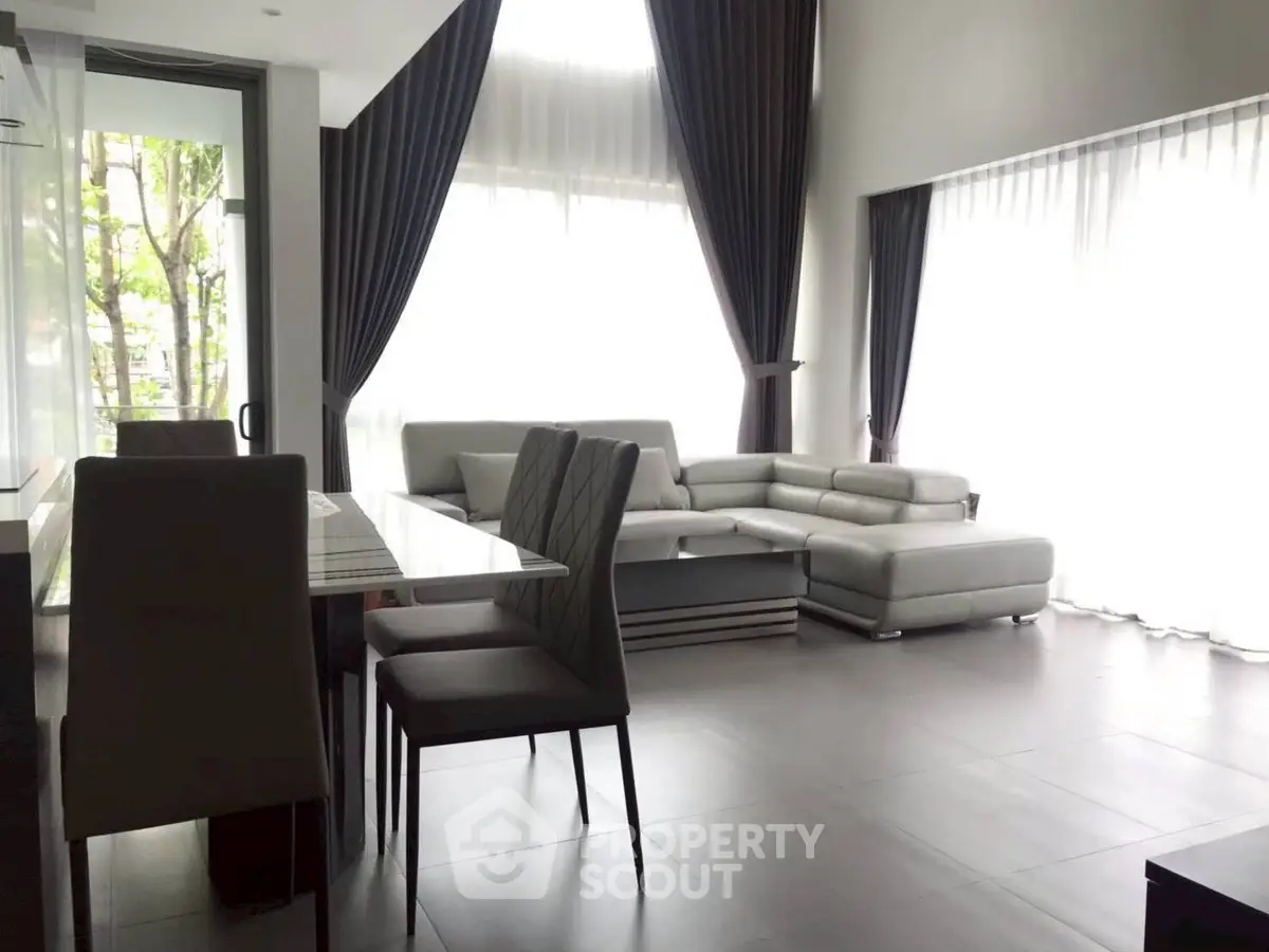 Spacious modern living room with large windows and elegant furniture