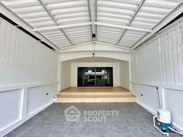 Spacious covered parking area with modern design and tiled flooring.