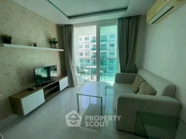 Modern living room with balcony view, featuring sleek furniture and natural light.