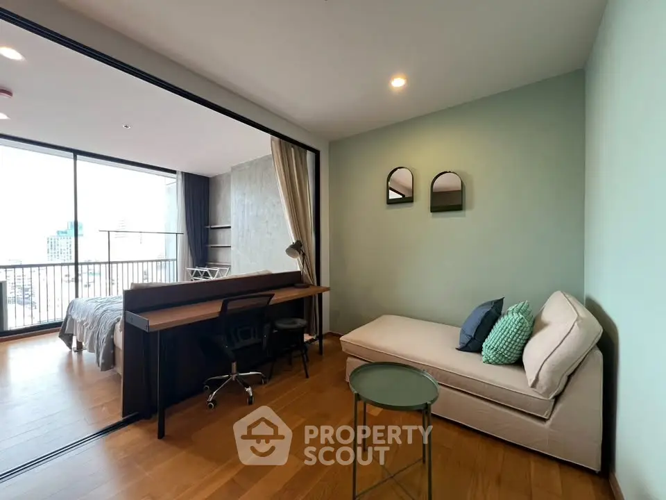 Modern studio apartment with cozy living area and city view balcony.
