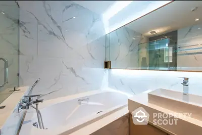 Luxurious marble bathroom with a sleek bathtub and modern fixtures, reflecting a taste of elegance and sophistication in a high-end property.