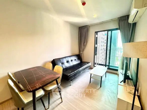 Modern living room with sleek furniture and balcony view in urban apartment.