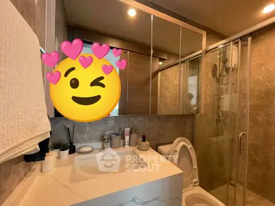 Modern bathroom with elegant marble tiles and glass shower enclosure.