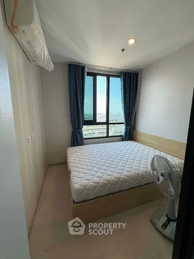 Cozy bedroom with city view, featuring a comfortable bed and modern decor.