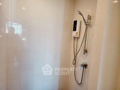 Modern bathroom shower with sleek white tiles and high-quality fixtures.