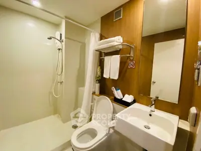 Modern bathroom with shower, toilet, and sink in sleek design