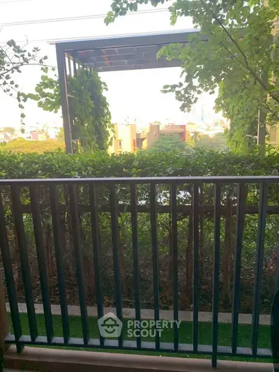 Charming balcony view with lush greenery and modern pergola, perfect for relaxation and outdoor enjoyment.