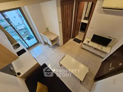 Modern compact living room with sleek furniture and large window view