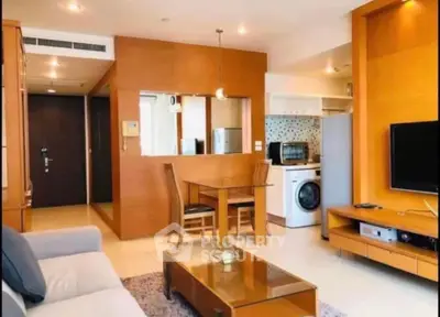 Modern living room with open kitchen, featuring stylish furniture and built-in appliances.