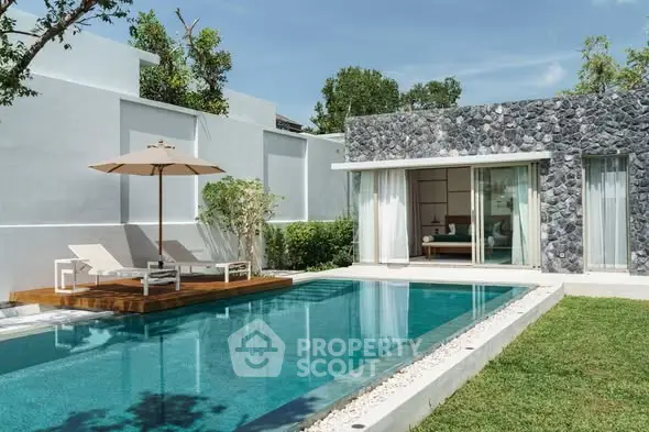 Luxurious villa with private pool and modern stone facade in tropical setting.