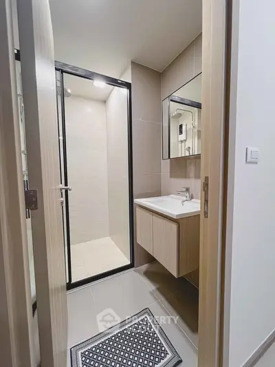 Modern bathroom with sleek shower and stylish vanity in contemporary apartment.