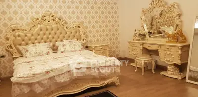Luxurious bedroom with ornate furniture and elegant decor, featuring a lavish bed and vanity set.