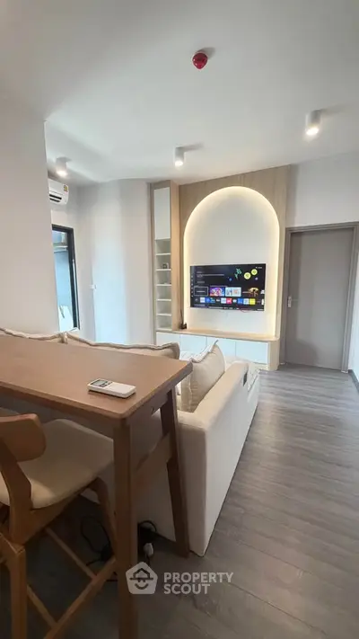 Modern living room with stylish TV setup and cozy seating area in a contemporary apartment.