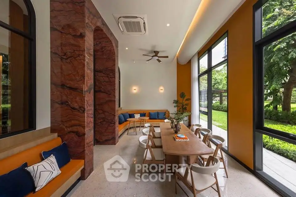 Stylish modern interior with large windows and elegant seating area, perfect for relaxation and gatherings.