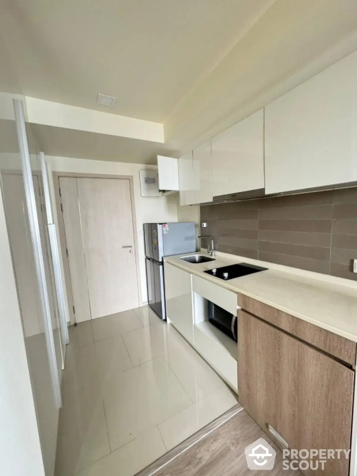 Modern kitchen with sleek cabinets and compact design in a contemporary apartment.