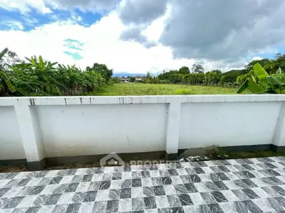 Scenic view from a tiled balcony overlooking lush greenery and blue skies.