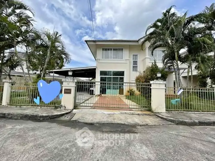 Charming two-story house with gated entrance and lush garden, perfect for family living.