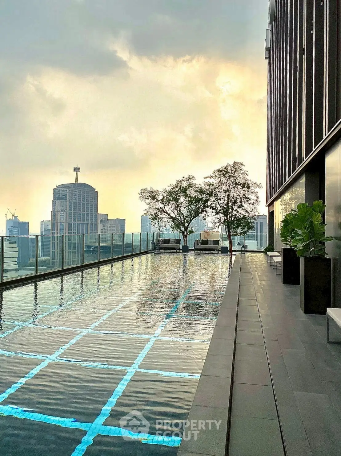 Luxurious rooftop pool with stunning city skyline views at sunset.