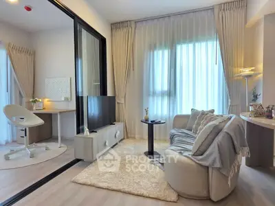 Modern living room with cozy seating and stylish decor, featuring a small workspace and large windows.