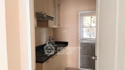 Cozy kitchen with gas stove and modern cabinetry in a compact layout.
