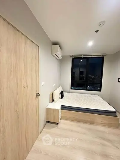 Modern bedroom with city view, featuring minimalist design and cozy ambiance.