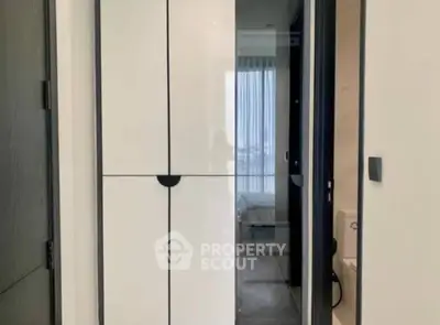 Sleek modern interior with a view into a cozy bedroom featuring elegant sliding doors and minimalist design, perfect for urban living.