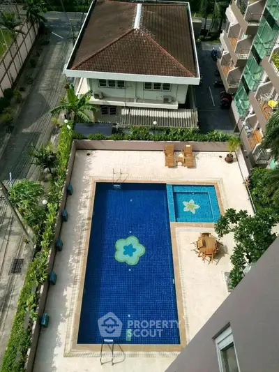 Stunning aerial view of a luxurious residential pool area with elegant seating and lush greenery.