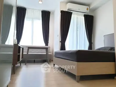 Modern bedroom with sleek furniture and large windows for natural light.