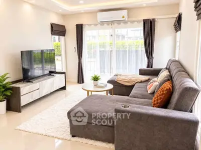 Spacious modern living room with plush sectional sofa and large TV, perfect for relaxation.