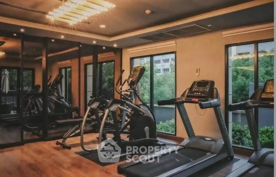 Modern gym with treadmills and elliptical machines in a luxury apartment complex.