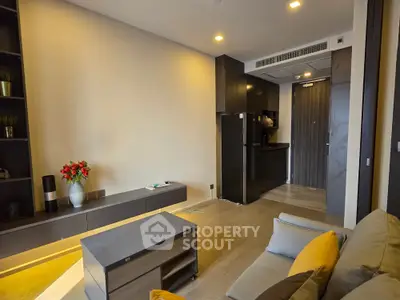 Modern living room with sleek furniture and open kitchen layout in a stylish apartment.