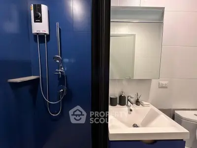 Modern bathroom with sleek shower and stylish sink in contemporary apartment.