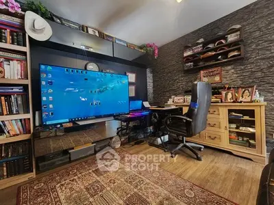 Cozy home office with large screen, bookshelves, and stylish decor