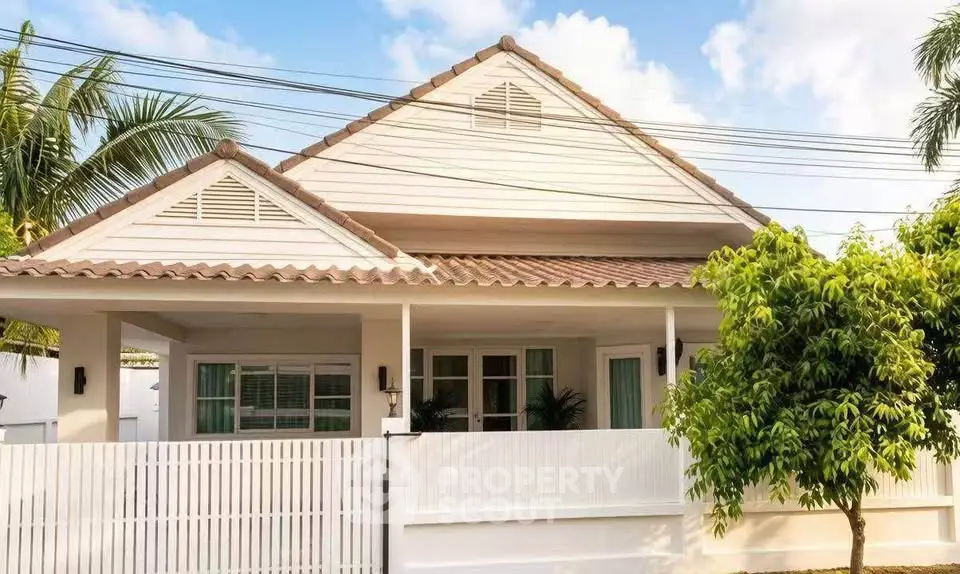 Charming single-story house with a white picket fence and lush greenery
