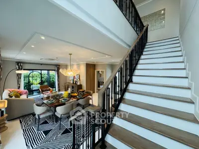 Luxurious open-plan living room with stylish dining area and modern staircase