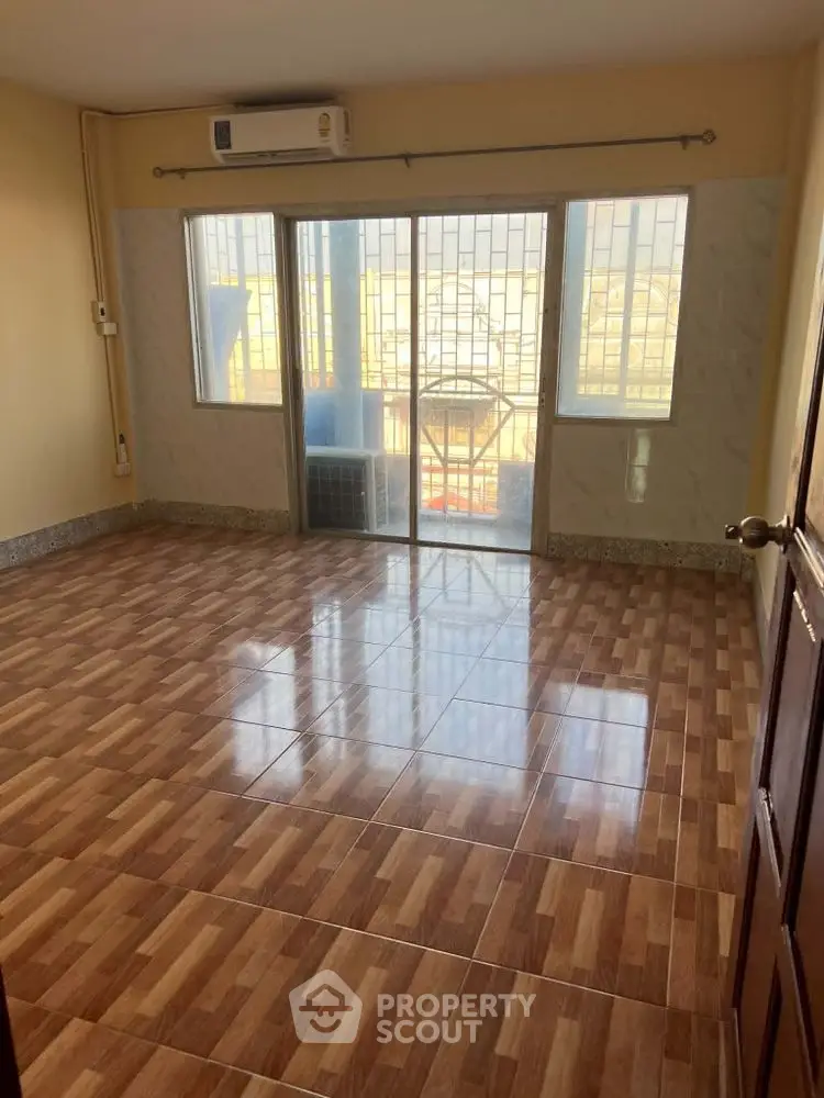 Spacious empty room with large windows and tiled flooring, perfect for customization.