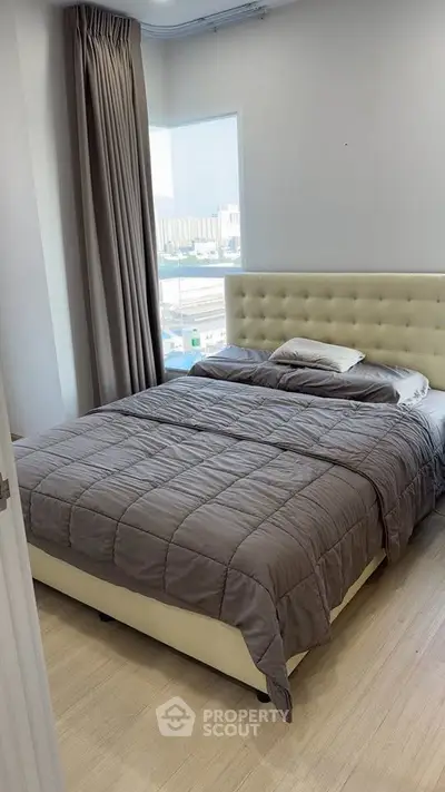 Cozy bedroom with large window and modern decor in a stylish apartment.