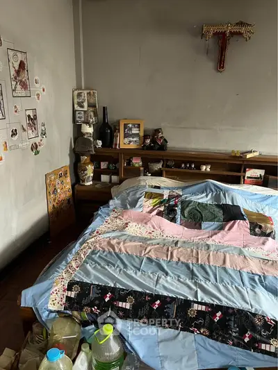 Cozy bedroom with colorful quilt and eclectic decor, showcasing a warm and inviting atmosphere.
