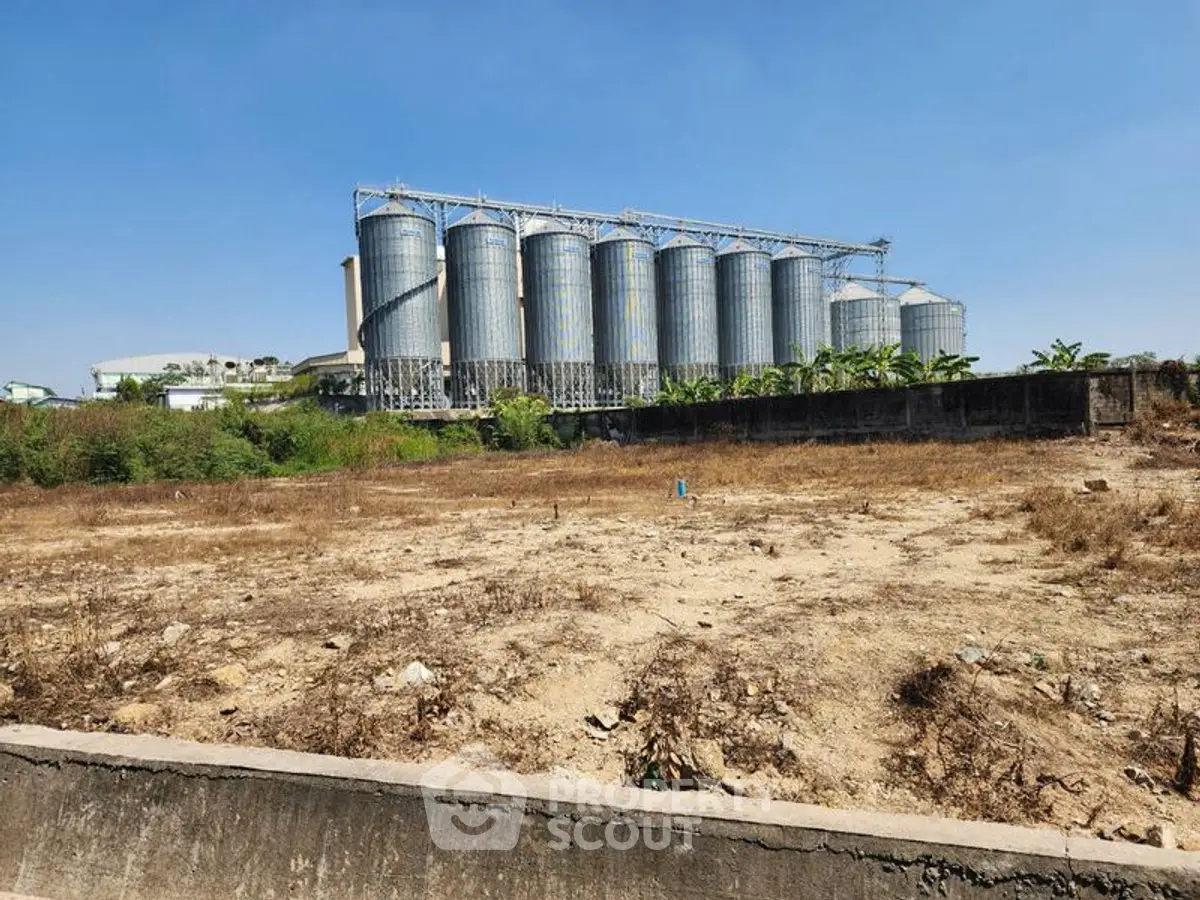 Expansive industrial land with silos, ideal for development opportunities.